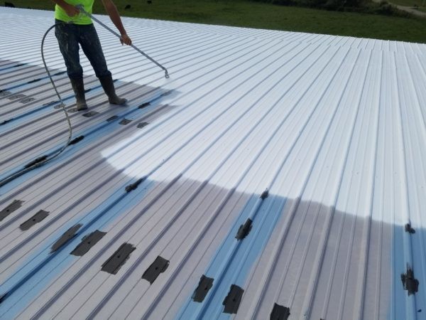 Commercial roofing contractor applying product.
